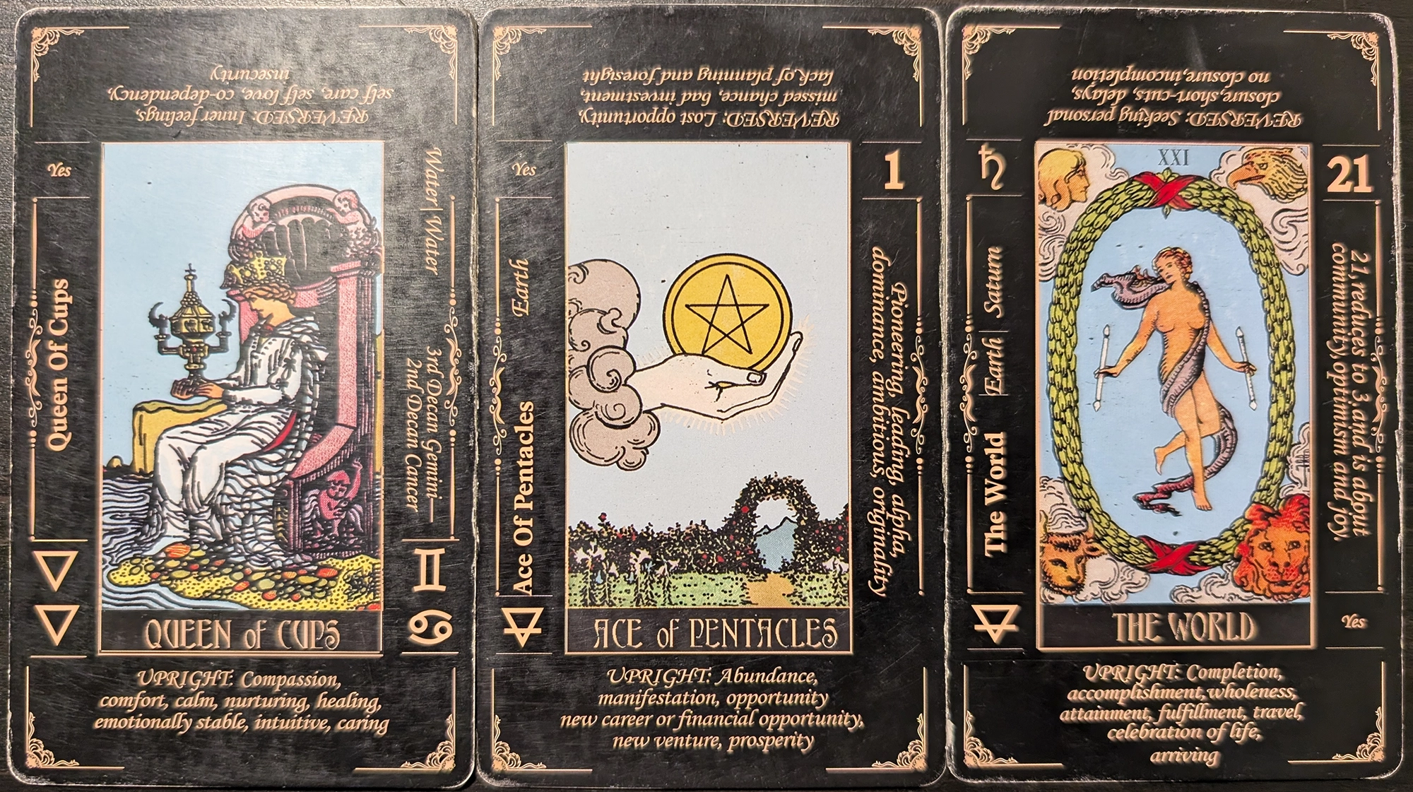 3 cards from the Classic Tarot deck os the Queen of Cups, Ace of Pentacles, and The World.