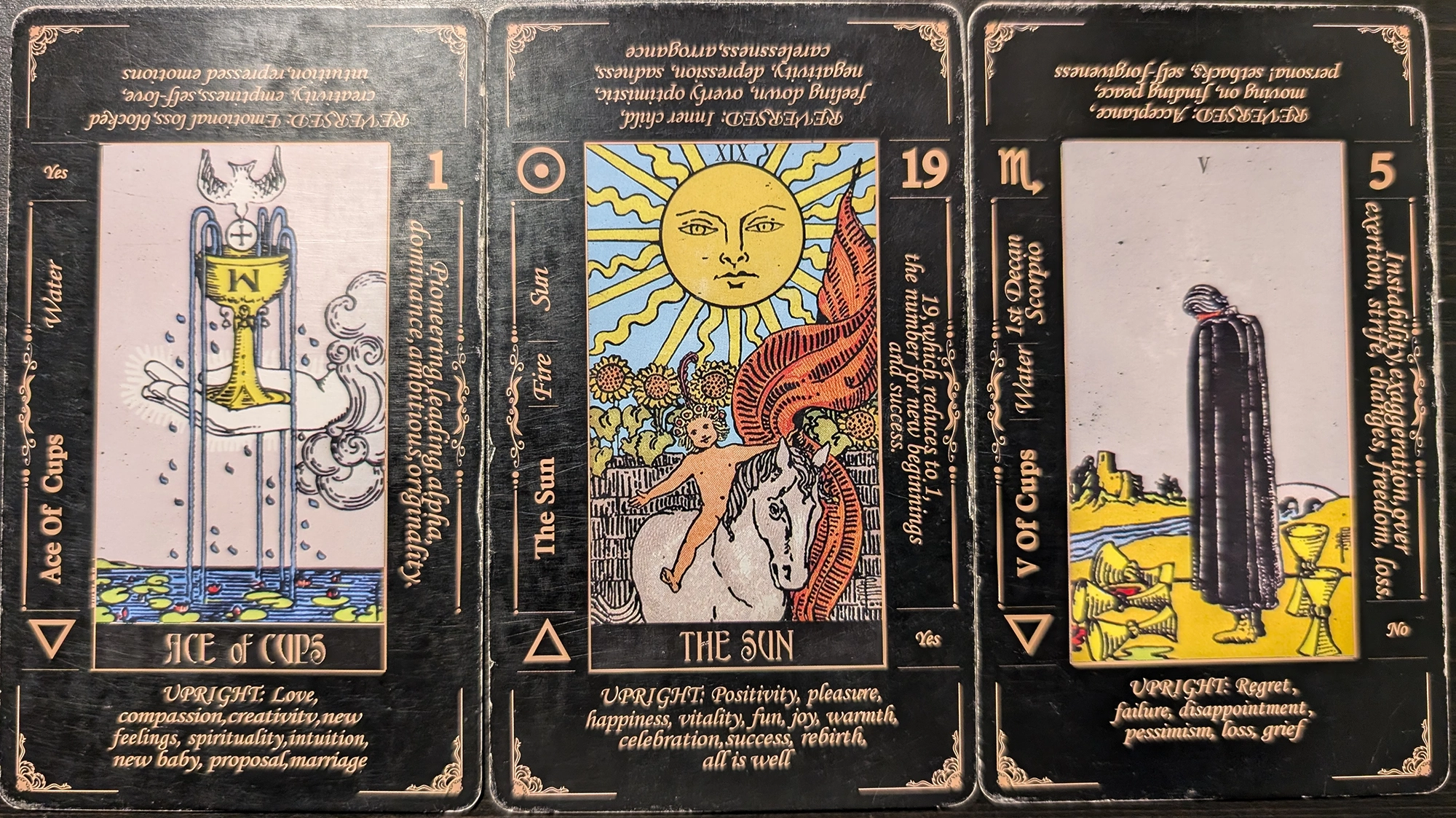 3 cards from the Classic Tarot deck of the Ace of Cups, The Sun, and the Five of Cups. 