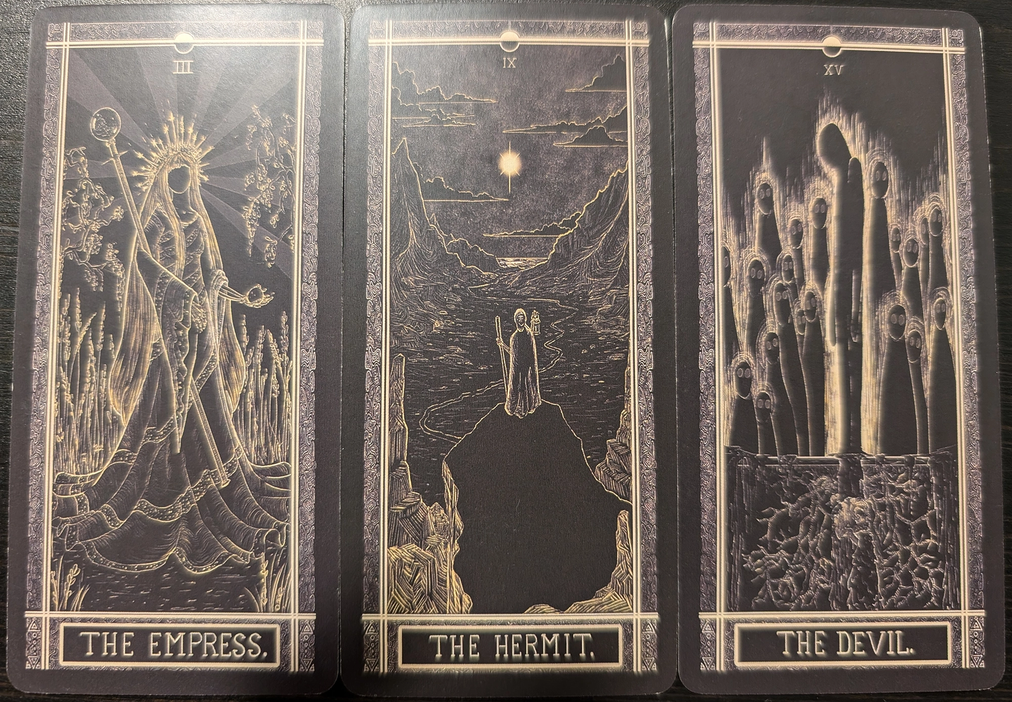 3 cards from The Kinner Tarot deck of: The Empress, The Hermit, and The Devil. 