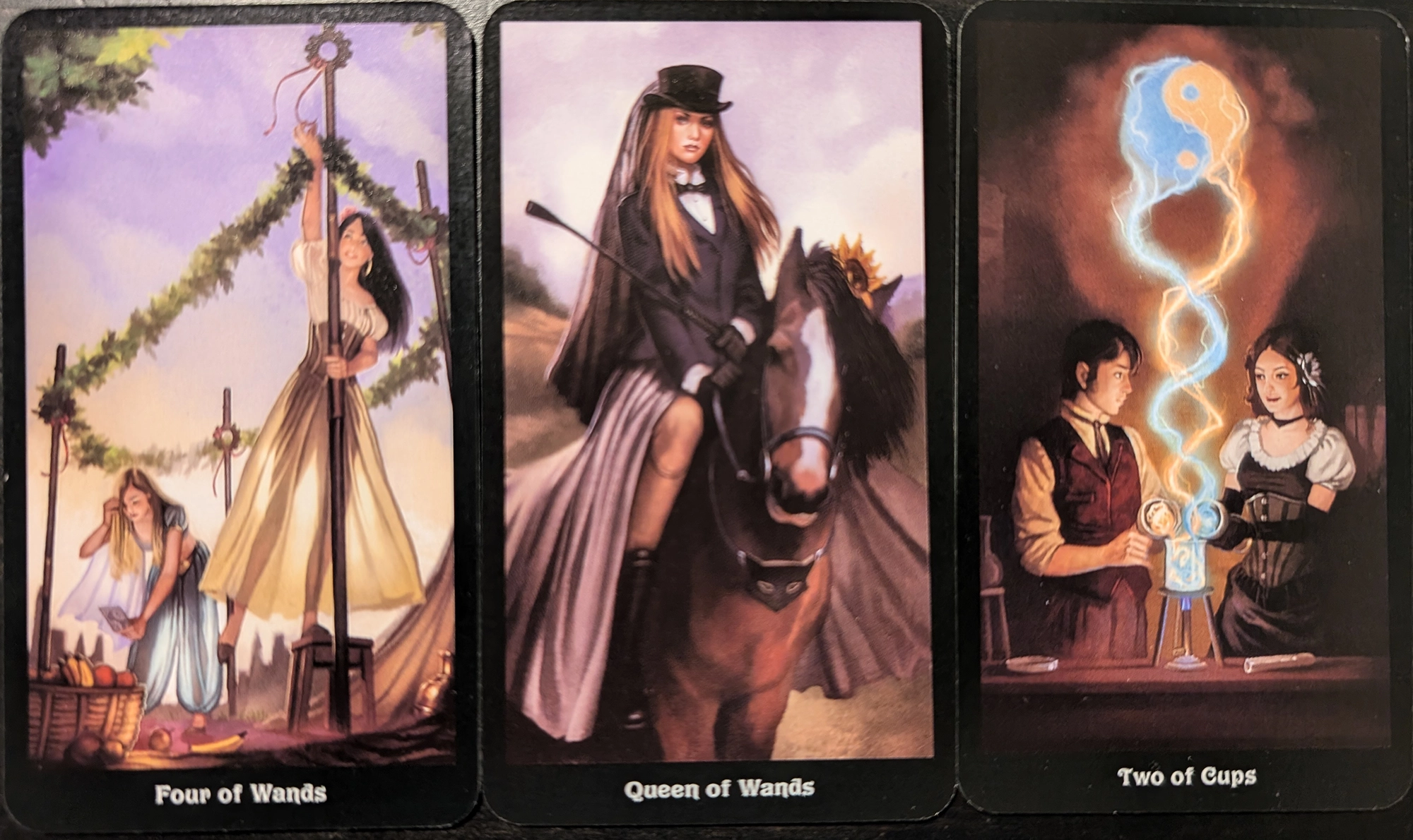 3 cards from the Steampunk taror of the Four of Wands, Queen of Wands, and Two of Cups. 