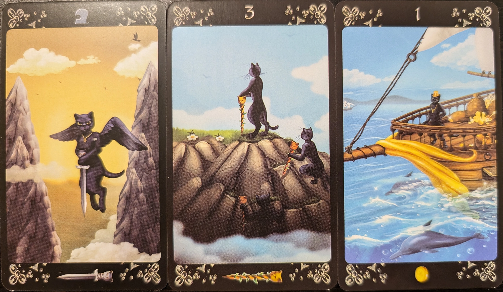 3 cards from Black Cats Tarot of Page of Swords, Three of Wands, and the Ace of Pentacles.