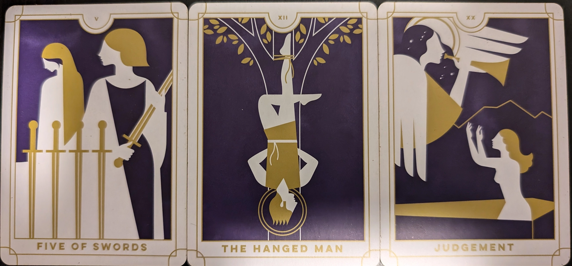 3 cards from the EVeryday Tarot of the Five of Swords, the Hanged Man, and Judgement