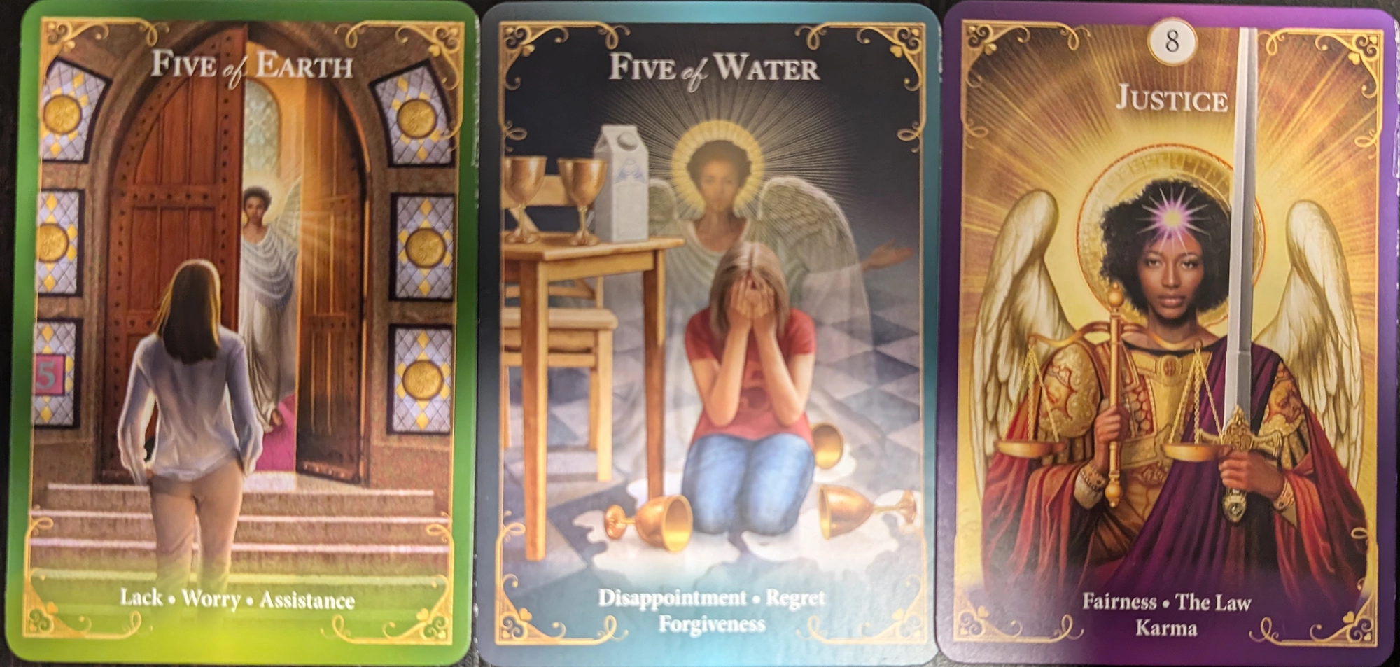 3 cards from the Guardian Angel Messages Tarot of Five of Earth, Five of Water, and Justice. 