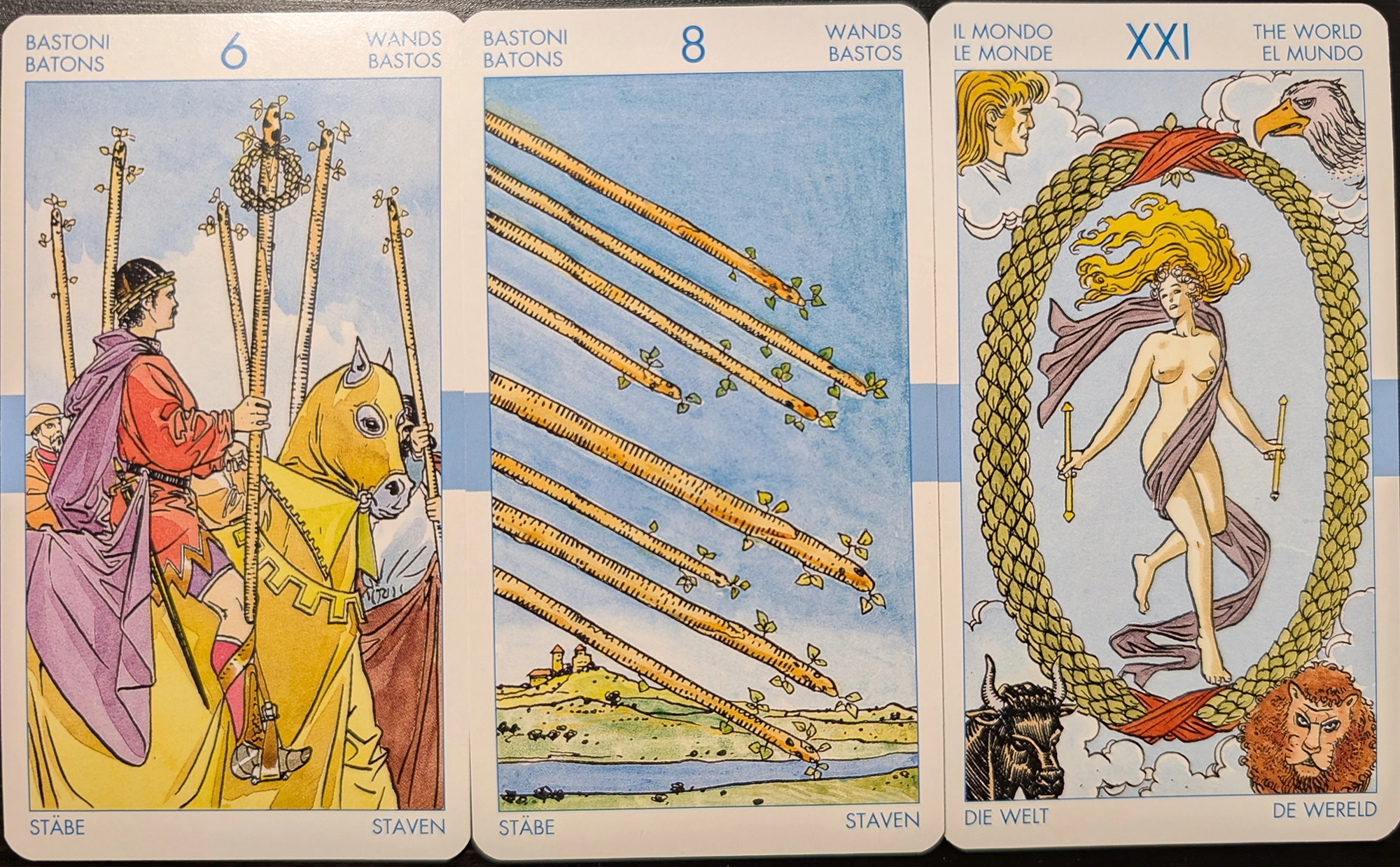 3 cards from the Universal Tarot of the Six of Wands, Eight of Wands, The World. 