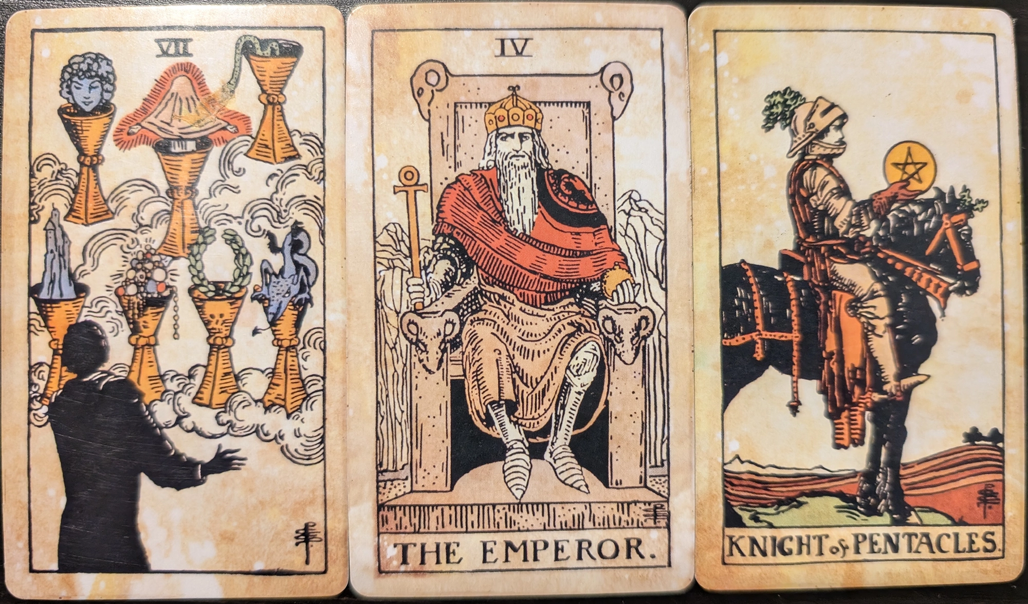 3 cards from the Tarot Vintage deck of the Seven of Cups, The Emporer, and Knight of Pentacles. 